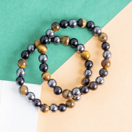 Triple Protection Bracelet Protection • Grounding • Confidence Experience the powerful synergy of Tiger's Eye, Black Tourmaline, and Hematite—three renowned crystals thoughtfully combined to support protection, grounding, and inner strength. Designed for everyday wear, this bracelet helps you stay centered, focused, and energetically balanced while navigating the demands of daily life. Crystal Benefits 🟤 Tiger's Eye Encourages confidence and courage Enhances focus and decision-making Promotes motivation and personal strength ⚫ Black Tourmaline Helps shield against negative energies Supports emotional balance and stability Encourages a sense of security and protection ⚙️ Hematite Grounds and stabilizes your energy Improves mental clarity and concentration Promotes balance, resilience, and calmness Why You'll Love It Crafted with genuine Tiger's Eye, Black Tourmaline, and Hematite beads Ideal for daily wear, meditation, travel, and work A meaningful gift for anyone seeking protection, confidence, and emotional balance Suitable for both men and women Care Instructions To maintain your bracelet's beauty and energetic integrity, avoid prolonged exposure to water, perfumes, and harsh chemicals. Cleanse and recharge your crystals regularly using your preferred spiritual practice. Disclaimer: Crystal healing is a complementary spiritual practice and is not intended to diagnose, treat, cure, or prevent any medical condition. The bracelet is designed to support your wellness journey alongside a healthy lifestyle.